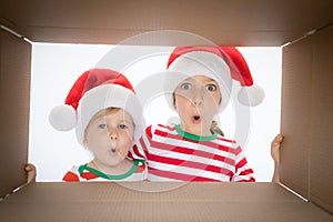 Surprised children unpack Christmas gift box