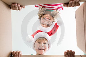 Surprised children unpack Christmas gift box