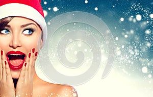 Surprised Christmas girl. Beauty woman in Santa`s hat