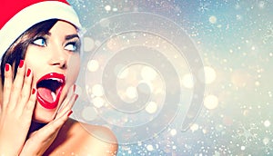 Surprised Christmas girl. Beauty woman in Santa`s hat