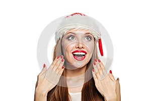 Surprised Christmas woman in Santa hat and red manicured nails isolated on white background. Christmas and New Year portrait