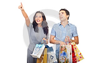 Surprised couple at shopping pointing up