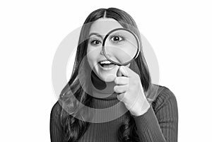 surprised curious teen girl in studio. curious teen girl with magnifying glass.