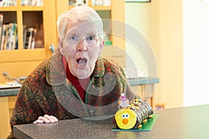 Surprised elderly woman with her birthday cake