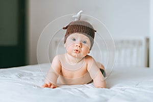 surprised emotional infant child in knitted deer hat