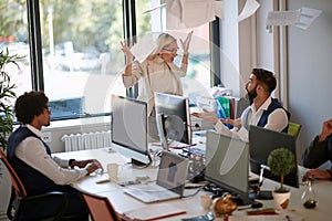 Surprised employee explaining to angry female boss who is throwing papers in the ear in front another employee. business,  stress