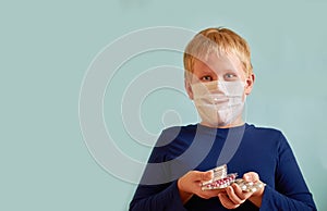 Surprised European boy stands and holds a lot of pills in his hands