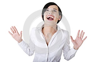 Surprised excited young business woman looking up