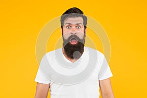 Surprised face expression bearded man yellow background, shocking news concept