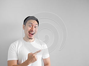Surprised face of happy man in white shirt light grey backgroun
