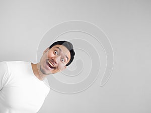 Surprised face of happy man in white shirt light grey backgroun