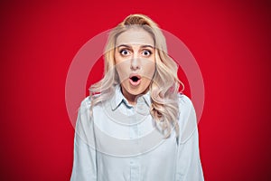 Surprised face of woman stare to camera, isolated on red background. Surprise expression face - head of a amazed girl. Wao - omg