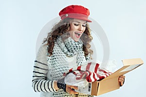 Surprised female looking inside opened parcel with sweater