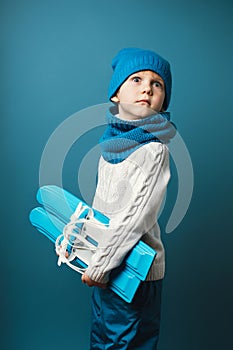 Surprised funny child kid with skis in hands. Concept of children recreation and sport