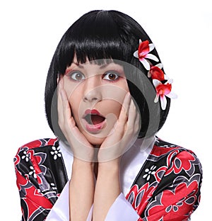 Surprised geisha, portrait of young woman in kimono and beautiful flowers in her black short hair isolated on white