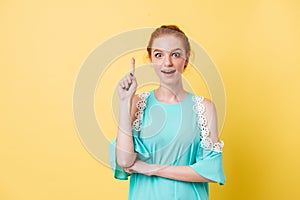 Surprised ginger woman in dress having idea