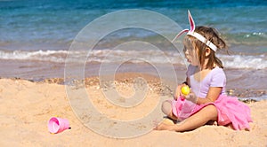 Surprised girl with easter eggs on the beach