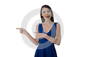 Surprised girl indicates a blank space for your text. Isolated on white background