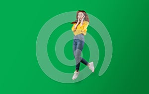 Surprised Girl Jumping In Air Posing Over Green Background