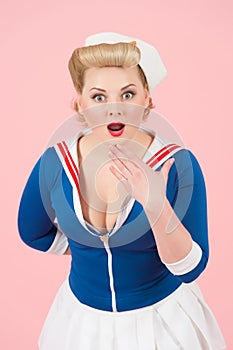 Surprised girl in pin-up style with hand over mouth. Surprised and amazed girl with wide open mouth.