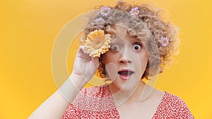 Surprised Girl Posing With Gerbera Daisy Flower Isolated Over Yellow Background