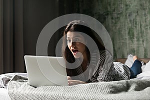 Surprised girl shocked receiving unexpected message at laptop