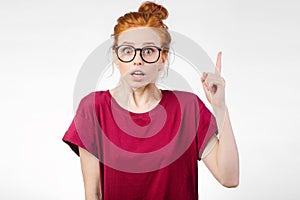 Surprised girl showing copy space with finger white background. girl pointing up