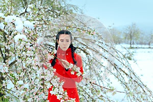 Surprised Girl By Snow Covering Spring Flowers in Blossoming Tree