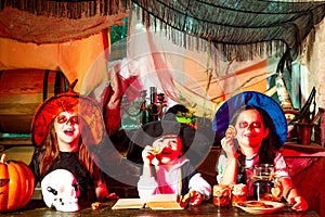 Surprised group little zombie in Halloween costume eating treat - calaverita sweets candles. Children friends with photo