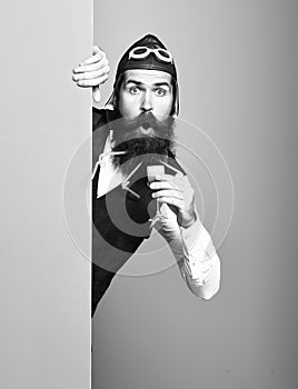 Surprised handsome bearded pilot on colorful studio background