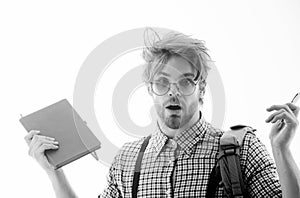 Surprised handsome man in nerd glasses holding pen and notebook