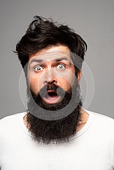 Surprised handsome man. Shocked male model with surprise expression, wow amazed excited face. Barber with long beard and