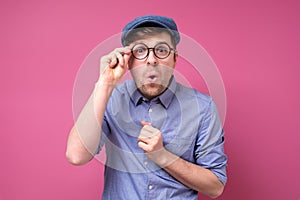 Surprised handsome man in summer hat and glasses being surprised.