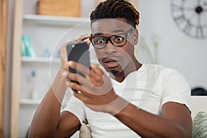 surprised happy african man holding phone