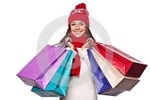 Surprised happy beautiful woman holding shopping bags in excitement. Christmas girl on winter sale, isolated on white background
