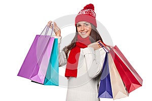 Surprised happy beautiful woman holding shopping bags in excitement. Christmas girl on winter sale, isolated