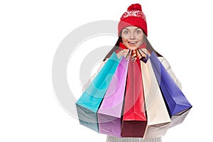 Surprised happy beautiful woman holding shopping bags in excitement. Christmas girl on winter sale, isolated on white