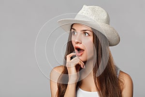 Surprised happy beautiful woman looking sideways in excitemen, isolated on gray background