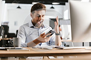 Surprised happy business man using smartphone and rejoice