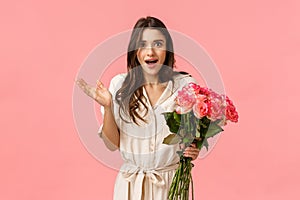 Surprised and happy, excited pretty young woman receive flowers and looking astonished by romantic nice gesture, didnt