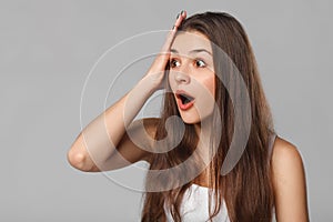 Surprised happy woman looking sideways in excitement, isolated on gray background