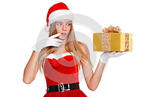 Surprised happy young woman in santa claus clothes looking on christmas gift in excitement. Isolated over white background