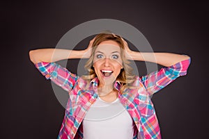 Surprised happy young woman touching her head and screaming