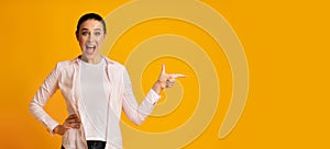 Surprised Lady Pointing Finger At Free Space On Yellow Background