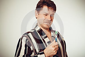 Surprised man in bathrobe brushing teeth