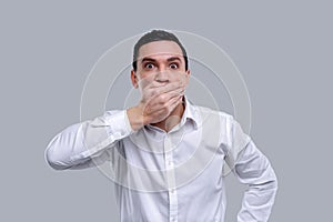 Surprised man closing his mouth with his hands