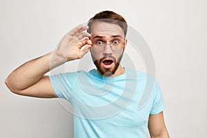 Surprised man dressed casually looking through glasses