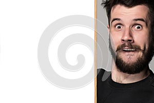 The surprised man and empty blank over gray background