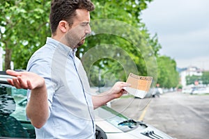 Surprised man finding parking ticket fine on his car