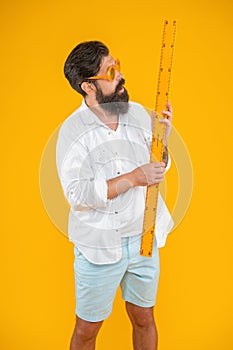 surprised man hold measuring ruler in studio. man hold measuring ruler on background.